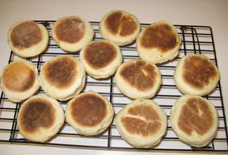 English muffins cooling on a pastry rack.